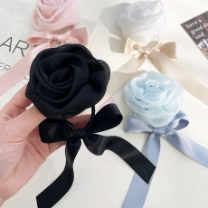 Detail of elegant satin rose hair ribbons with long streamers in multiple colors