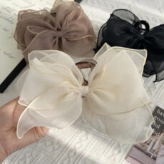Detail of layered organza bow hair clips in cream, coffee and black colors