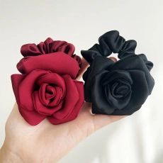 Detail of satin fabric rose hair ties in burgundy and black with elastic band
