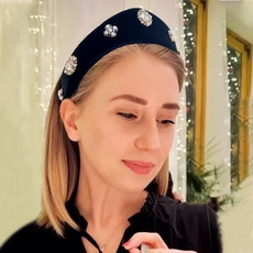 Detail of knot headband with rhinestones and pearls on black velvet fabric