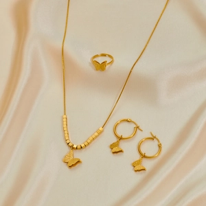 Conjunto de joyas de mariposa dorada con collar, anillo abierto y pendientes sobre seda