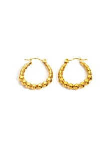 Close-up of gold vintage hoop earrings with gradient metal beads on white background