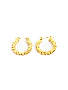 Detail of gold-plated hoop earrings featuring textured stripes and X-shaped motifs