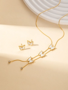 Dettaglio di un set di collana e orecchini a farfalla dorata con inserti in madreperla