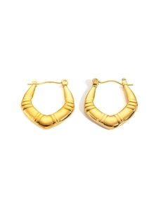 Macro detail of gold V-shaped hinged hoop earrings with textured tiered metal design