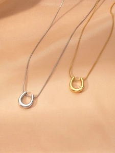 Detail view of U-shaped gold and silver necklaces on luxury champagne satin background