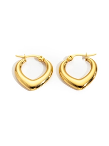 Detailed macro view of heart-shaped gold hoop earrings with polished metal finish