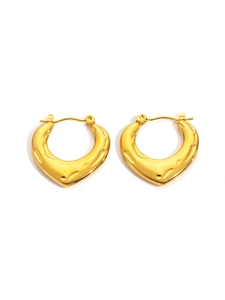 Detailed macro of golden heart-shaped hoop earrings with hammered metal texture