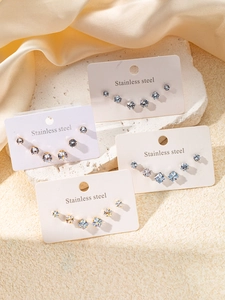Détail de boucles d'oreilles en acier inoxydable avec zircons ronds et carrés
