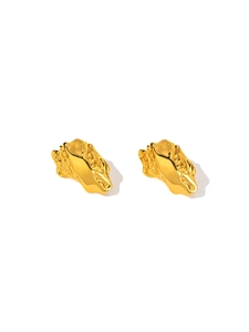 Macro detail of irregular lava texture and molten gold finish on titanium steel earrings