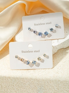 Détail macro de boucles d'oreilles en zircone carrée avec bases en acier doré et argent