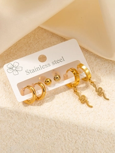 Detailed macro view of 3-pair gold stainless steel earring set with snake and bead motifs
