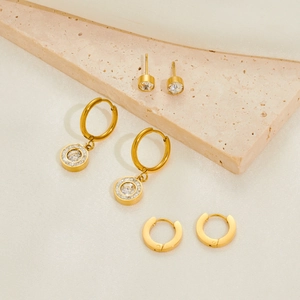 Detailed shot of three pairs of gold-plated titanium steel earrings with zircon stones