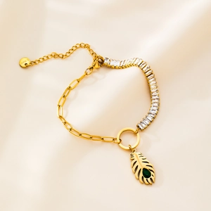 Close-up of gold steel feather pendant bracelet with green gemstone and zircon details