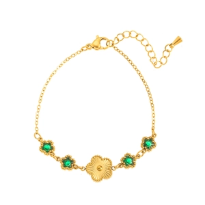 Détail du bracelet en acier doré avec gemmes étoiles vertes et breloque florale