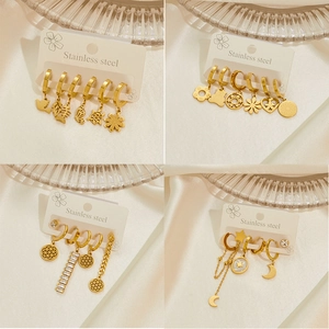 Gold stainless steel earring set with star moon and animal charms on silk background