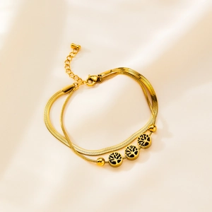 Golden double-layer bracelet with flat snake chain and tree of life charms on satin