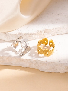 Dettaglio degli anelli aperti con ali di farfalla oro e argento su base di pietra