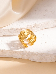 Dettaglio macro della trama dell'anello a foglia di ginkgo dorato su base in pietra