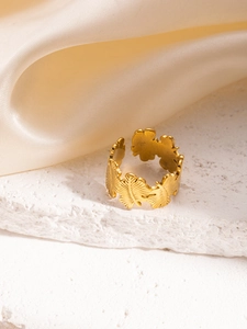Dettaglio macro del rilievo a foglia dorata su un anello in acciaio inox regolabile