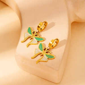 Macro shot of 18K gold-plated butterfly earrings with green and white enamel details