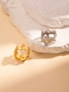 Detailed view of gold and silver hollow butterfly rings with fine brushed metal texture