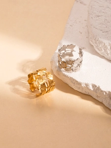 Detailed view of gold and silver ginkgo leaf hollow open rings on stone decor