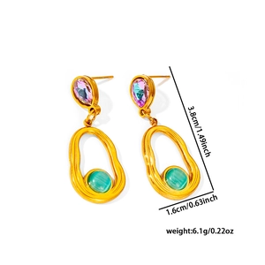 Macro detail of bohemian turquoise and pink teardrop earrings with gold tassel frame