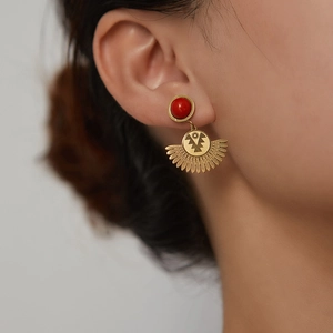 Macro view of vintage titanium steel earrings with red beads and sunburst fan pendants