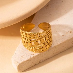 Detailaufnahme eines mehrlagigen goldenen Rings mit Scheibenakzenten auf Steinoberfläche
