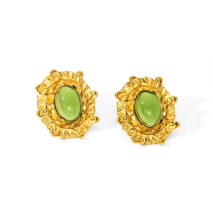 Detalle macro de pendientes vintage con piedras verde oliva y textura de oro de 18 quilates