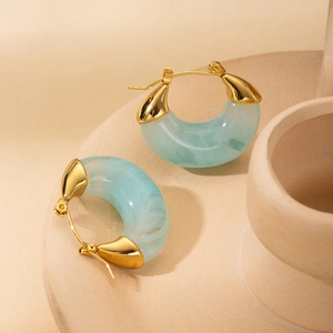 Dettaglio orecchini a forma di C placcati oro con inserto in resina effetto marmo blu