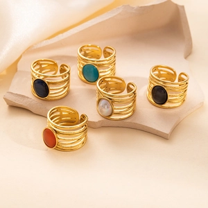 Detailed view of five adjustable open rings with colorful stones on beige stone props