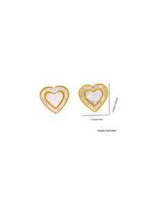 Dettaglio macro di orecchini a cuore dorati con inserto in conchiglia e zirconi bianchi