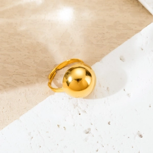 Polished gold titanium steel ring with oversized hemisphere design on marble background