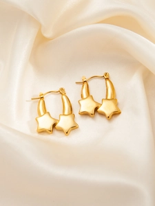 Detail of gold star hoop earrings on champagne satin showing textured metallic finish