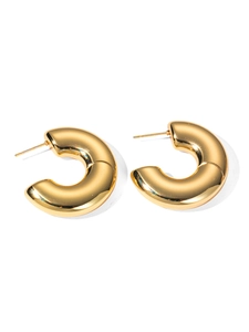 Detailed view of chunky golden hoop earrings with a high-polished mirror finish and C-shape