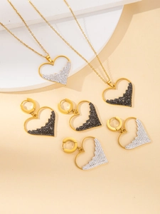 Detailed view of heart-shaped gold necklaces and earrings set with diamond pavé accents