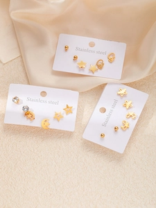 Détail de l'ensemble de boucles d'oreilles étoiles et cœurs en acier doré poli et strass