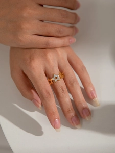 Detailaufnahme des goldenen Sternrings mit funkelnden Zirkoniasteinen am Finger getragen