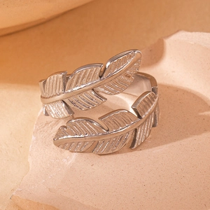 Détail de la bague plume argentée montrant les textures gravées complexes