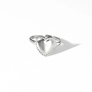 Détail de la bague coeur argentée avec texture perlée et anneau ajustable ouvert