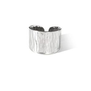 Bague large ouverte en acier titane minimaliste avec texture martelée sur fond blanc