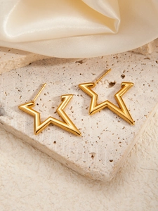 Polierte goldene Sternohrstecker aus Titanstahl auf einem Steinsockel präsentiert