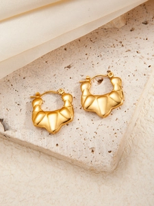 Strukturierte goldene Creolen mit Sternenelement und elegantem Wellendesign