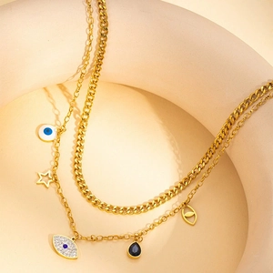 Collier double couche doré vintage avec œil grec et étoiles sur fond minimaliste