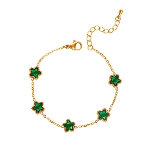 Detailed close-up of emerald green star charms on a polished gold stainless steel bracelet