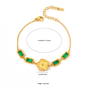 Detail of gold titanium bracelet featuring emerald crystals and a floral pendant with dimensions