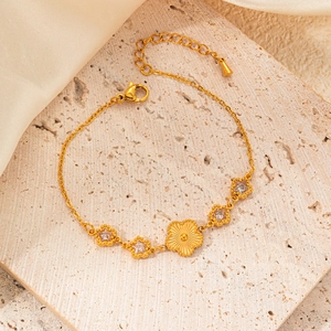 Detail of gold flower bracelet with emerald crystal petals and adjustable steel chain
