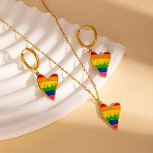 Close-up of golden heart pendant with rainbow enamel stripes and Love inscription